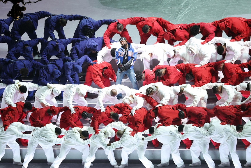Kendrick Lamar surrounded by dancers in red, white and blue at the Super Bowl half-time show.