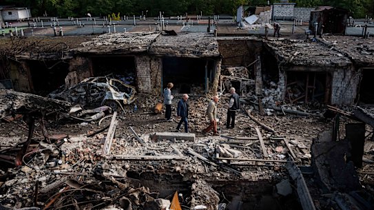 People walk in front of garages destroyed in a Russian missile strike on Vyshhorod, in the Kyiv region, in September.