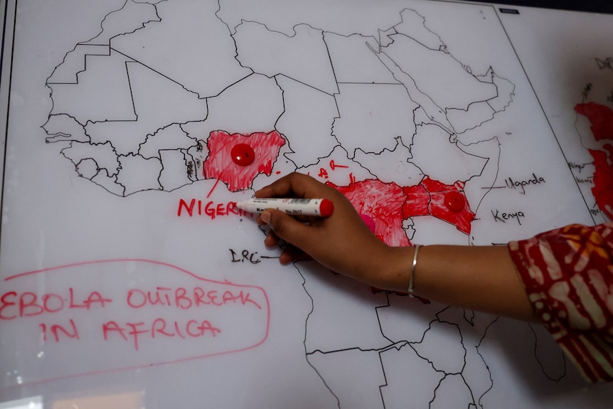 A person colours in a map of Africa to mark countries affected by Ebola.