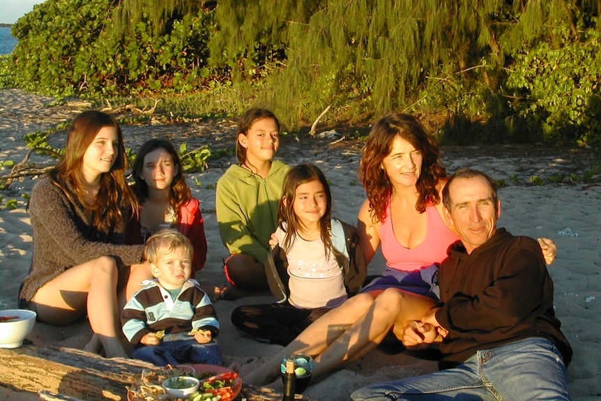 A family having a picnic on a beach at sunset
