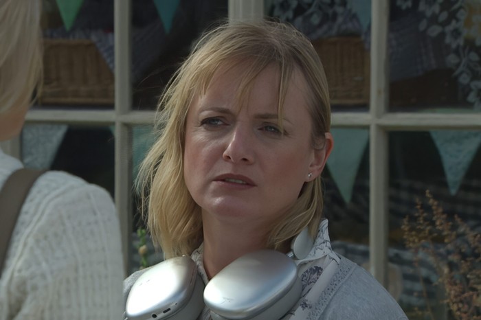 11_09_emm_nicola Nicola looks sad with a pair of headphones around her neck in a scene from Emmerdale