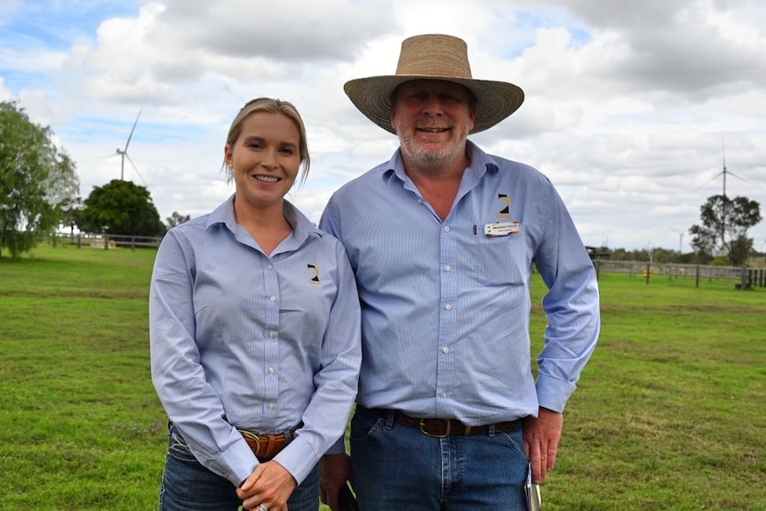 two people standing in field