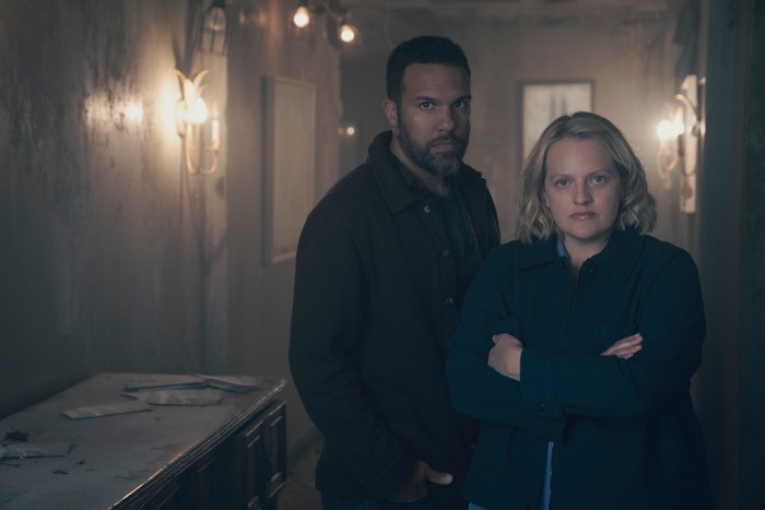 O-T Fagbenle and Elisabeth Moss in The Handmaid's Tale stood looking angry