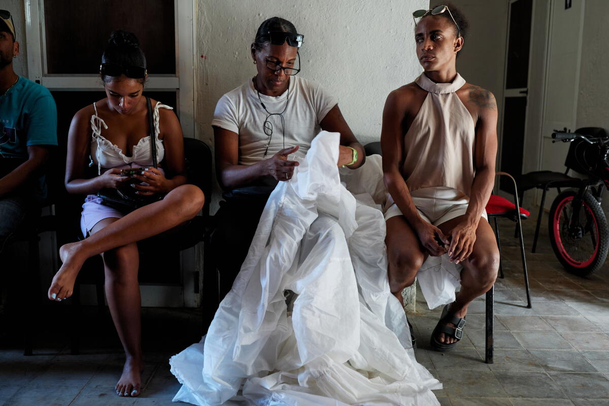 A woman mends a dress.