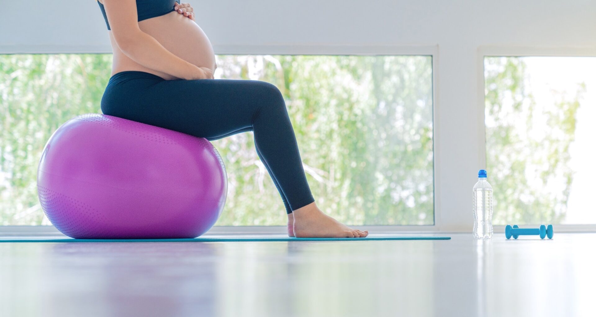 Pregnant woman balancing on exercise ball.