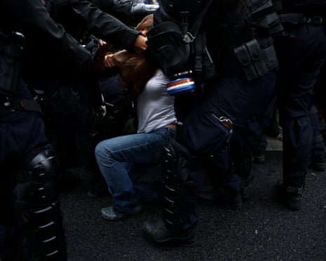 French riot police apprehend a protester amid clashes on the Boulevard Saint-Germain during a protest outside Sciences Po university in Paris.