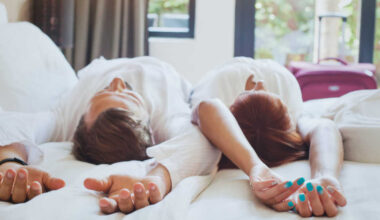 couple resting on top of hotel bed