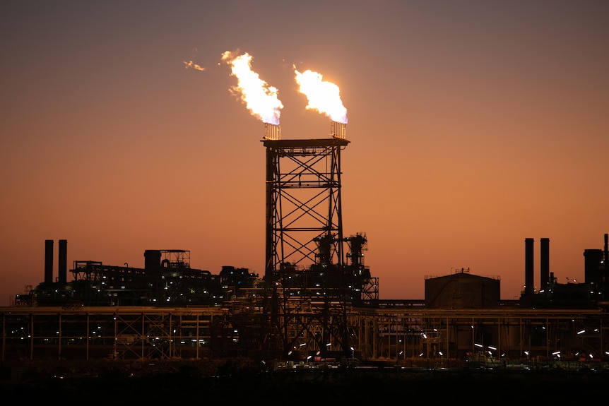 Large flames burn at the top of towers in Woodside Energy's Karratha Gas Plant 