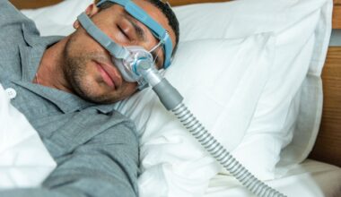 A person sleeps in bed wearing a CPAP mask for sleep apnea
