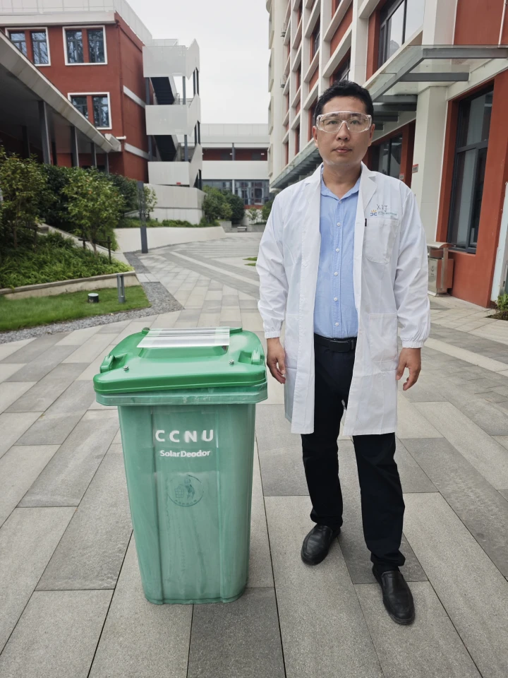 Researcher Jinlong Wang stands beside a garbage bin fitted with one of the inserts