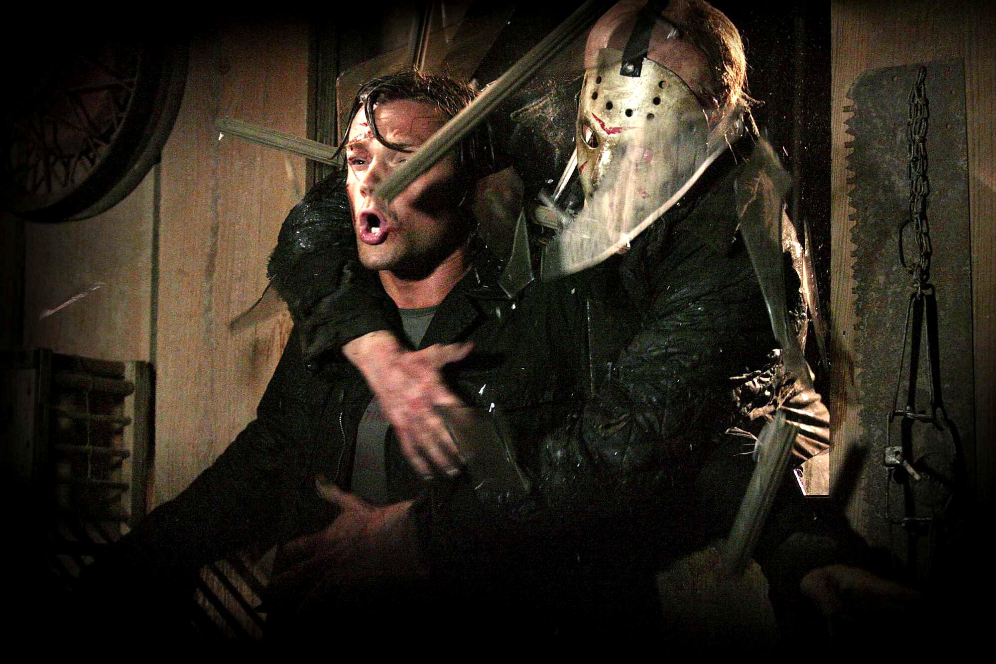 A screaming man is held by another man in a hockey mask.