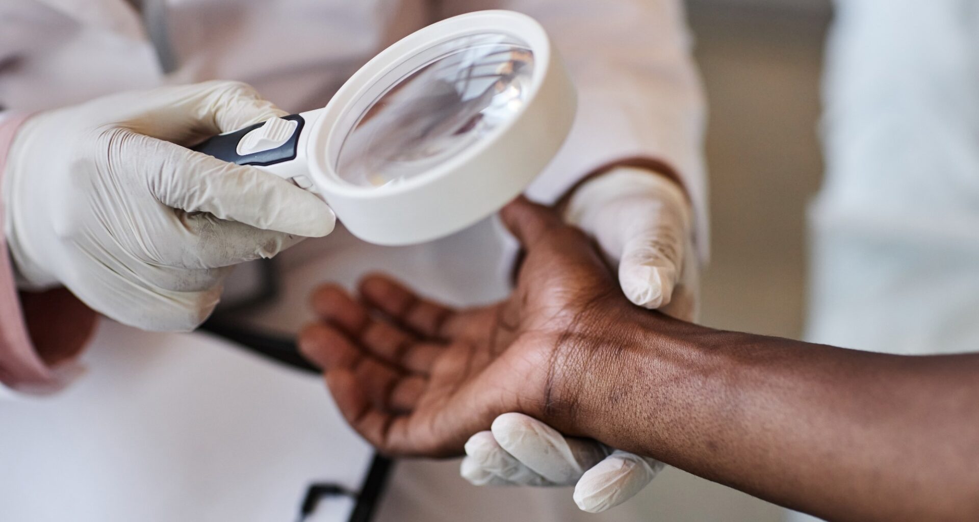 Clinician looking at skin of African American individual