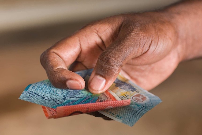 A person holds onto some money.