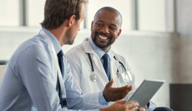 Two doctors having a discussion about a patient diagnosis, holding digital tablet.