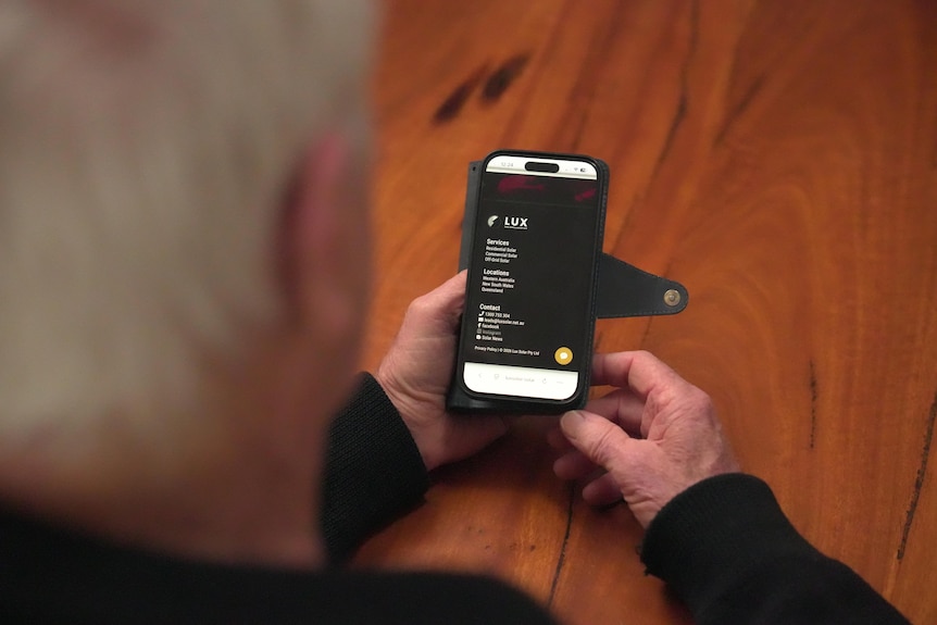 Bob Emery looks at his mobile phone