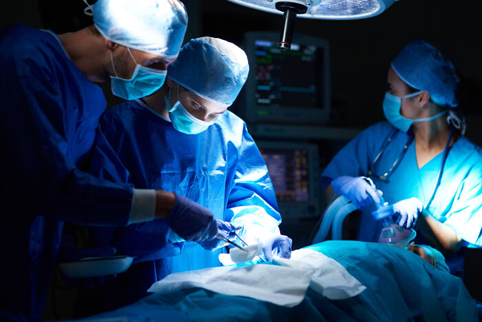 A team of doctors and surgical nurses performing a procedure in an operating room.