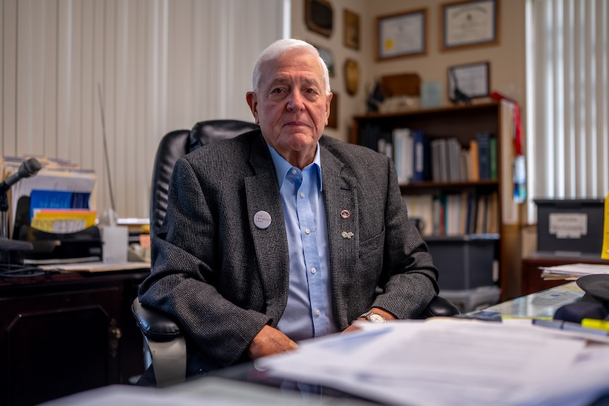 Hansen sits at an office desk.