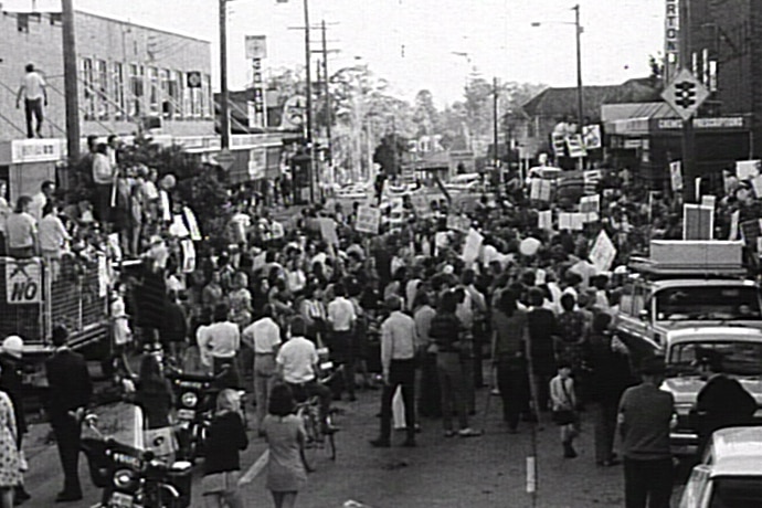 Black and white image of people gathered in the street