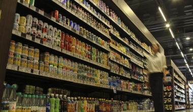 A woman walks down an aisle of sugar-sweetened beverages at a supermarket in Jakarta on Dec. 14, 2023.