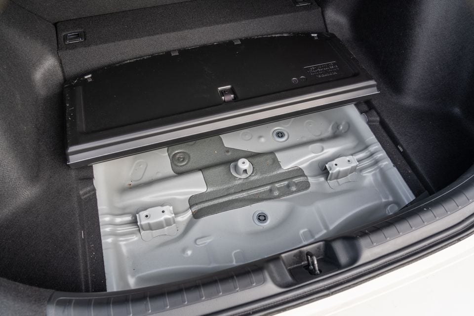 The open boot floor of a Honda Civic Type R with the spare wheel well cover lifted, revealing an empty metal storage area beneath