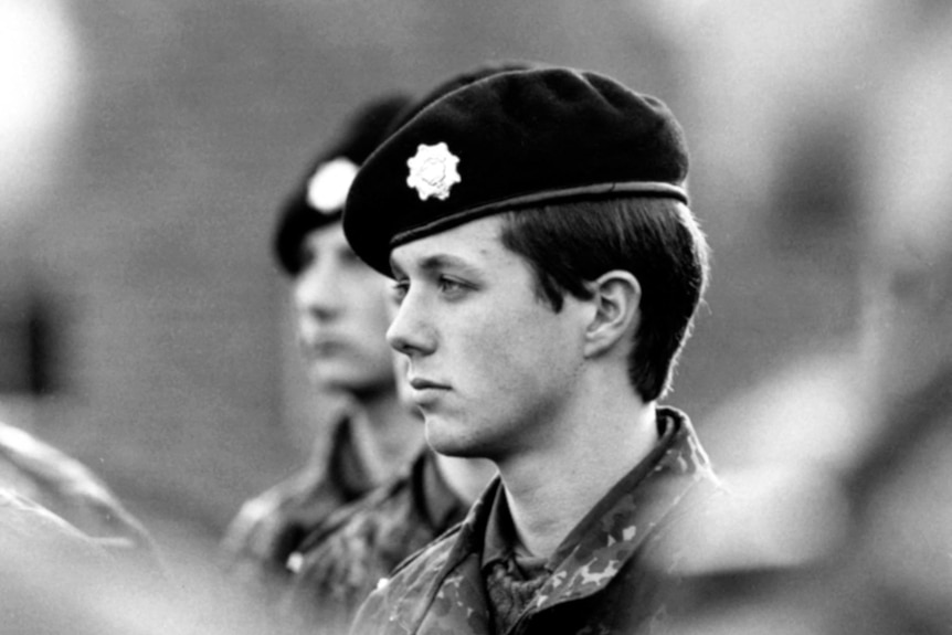 Black and white photo of a young man wearing an army beret with a metal star and fatigues