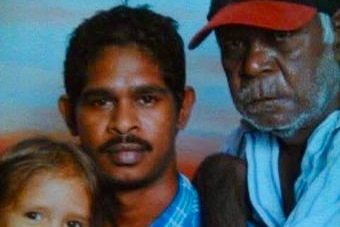 An old photograph of a young man in a blue collared shirt.