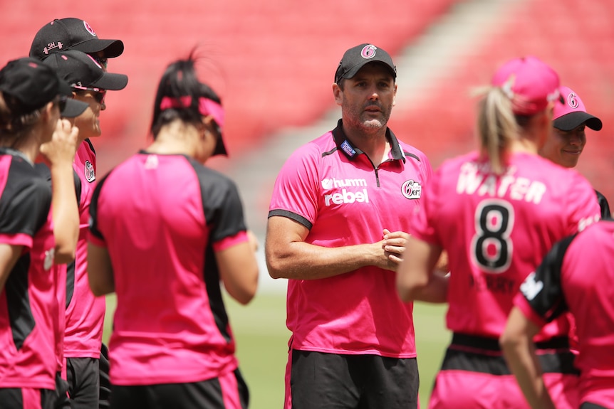 Ben Sawyer addresses his players on the field in his time as Sydney Sixers coach.