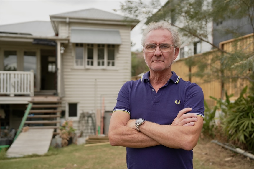 Justin Albin stands outside his home.