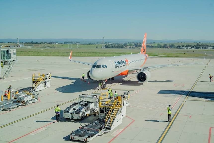 People wearing high-vis jackets inside the new airport terminal on a sunny day