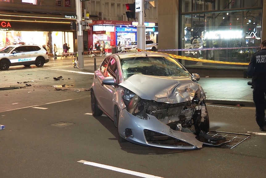 Smashed up silver car outside the QVB