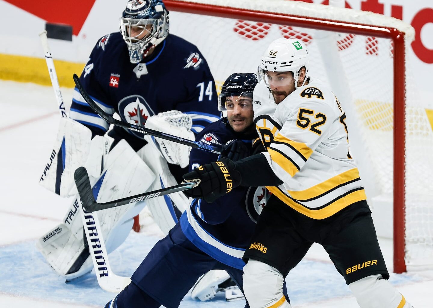 Sean Kuraly (right) is tangled up with the Jets' Dylan DeMelo during the Bruins 4-3 overtime win over the Jets on Friday night.