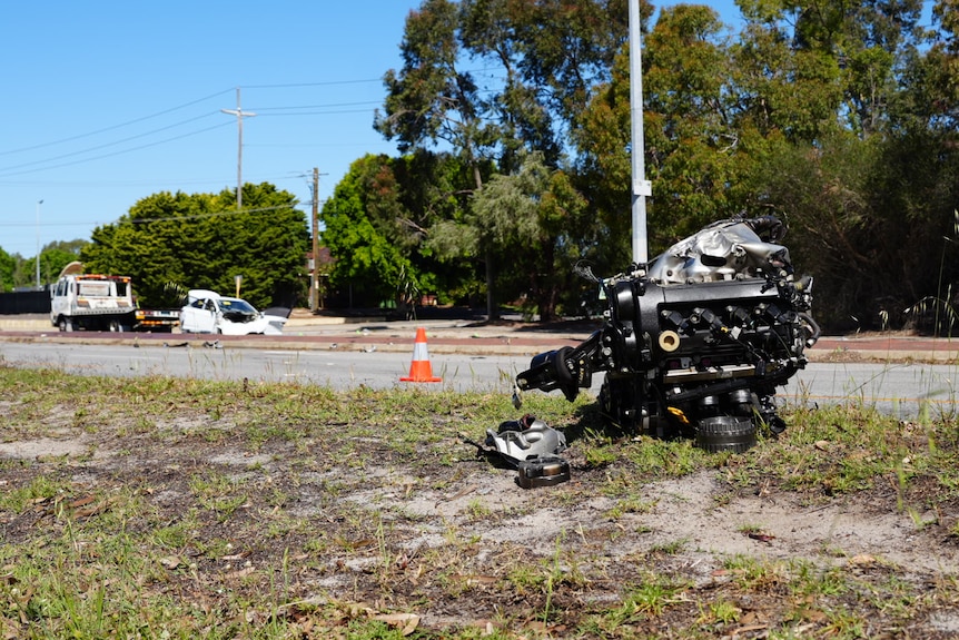 A car's engine lies by the side of the road