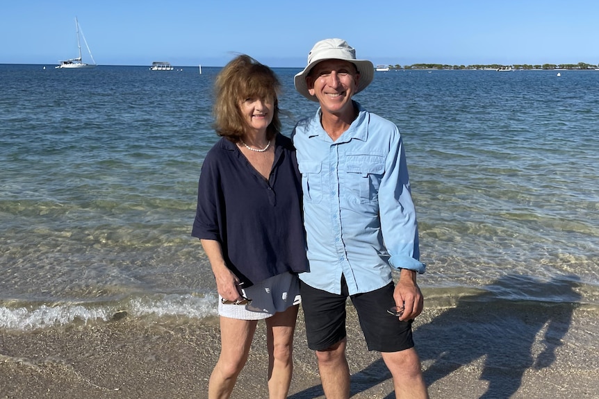 A man and a woman together on a white sandy beach