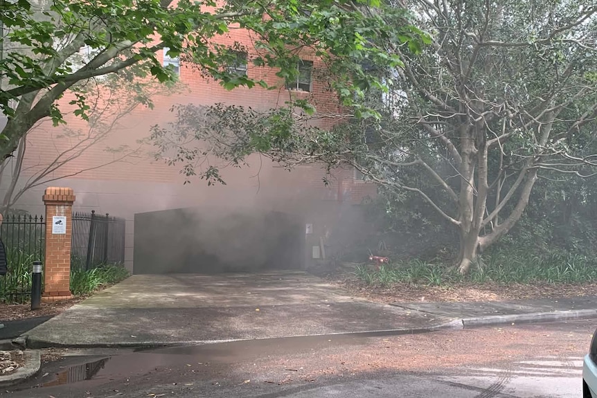 Gates driveway in leafy street with smoke cloud around