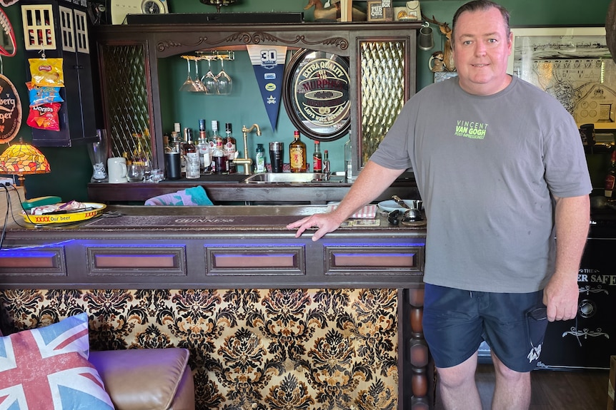 man standing next to bar