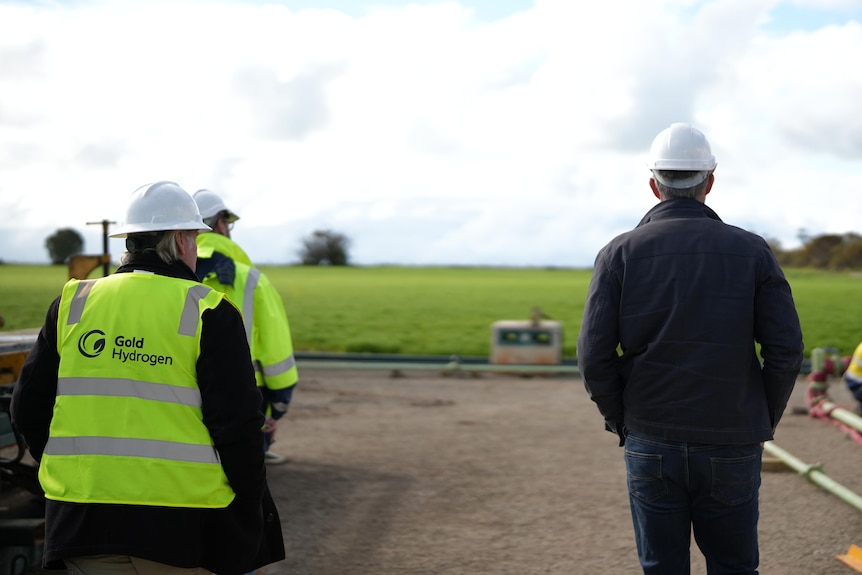 two men walking away from the camera on a work site