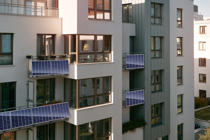 An apartment building with plug-in solar panels on the balconies.