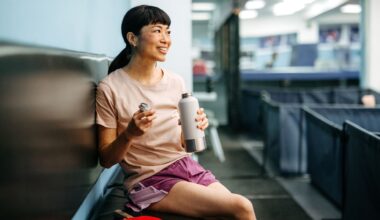 Woman drinking from water bottle at gym