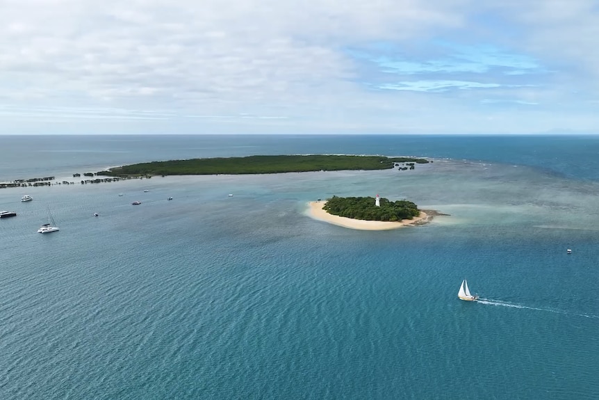 Aerial photo of two islands and sail boat