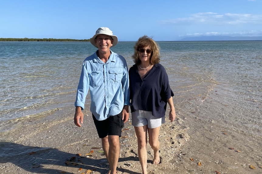 A man and woman walking together on a beach