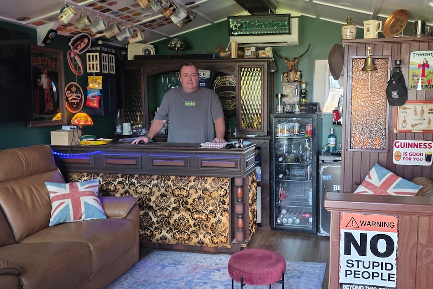 A man standing proudly behind a bar