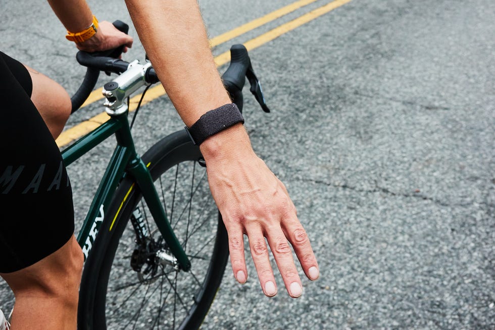 A cyclist’s outstretched hand signaling while gripping the handlebars on a road bike. A cyclist’s outstretched hand signaling while gripping the handlebars on a road bike.