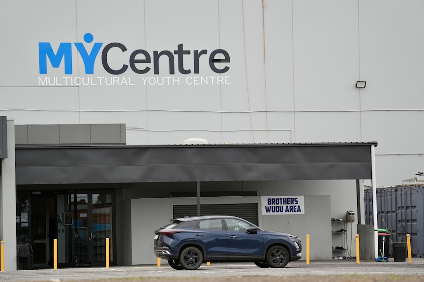 A building with signage reading 'My Centre: Multicultural Youth Centre' and a car out front