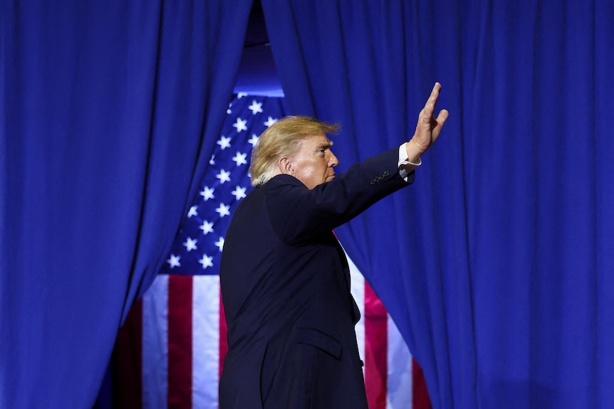 Trump waves at a crowd at a campaign rally