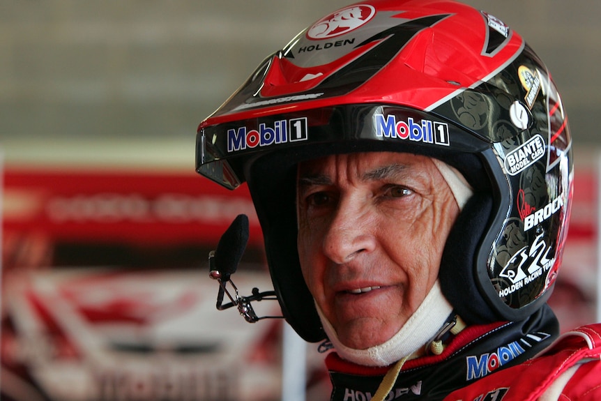 Racing driver in the pit garage wearing his helmet