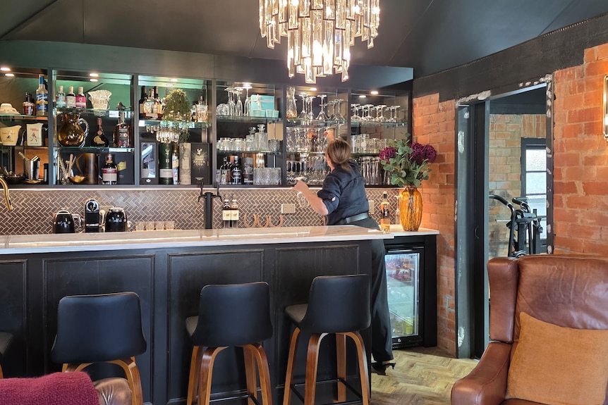 lady reaching for a glass in a bar