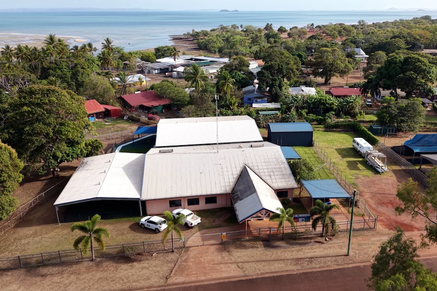 An aerial image of low set buildings for a block or two, then a beach and water on the horizon.