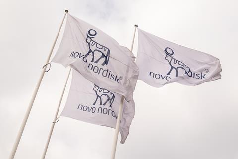 Novo Nordisk flags against a cloudy sky