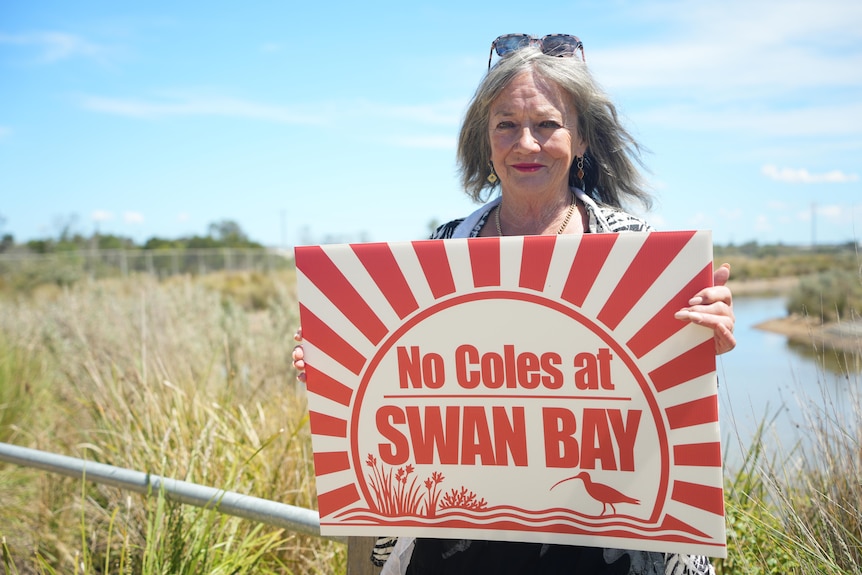 Campaigner Trish Berry holds a "No Coles at Swan Bay" sign. 