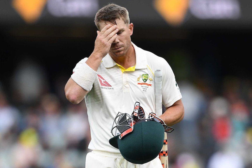 David Warner puts his right hand to his forehead as he walks off Adelaide Oval after being dismissed in second Ashes Test.